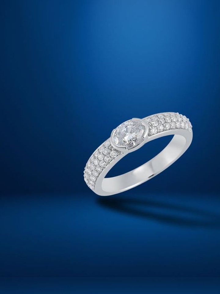 East-west oval bezel ring with pavé shank on blue